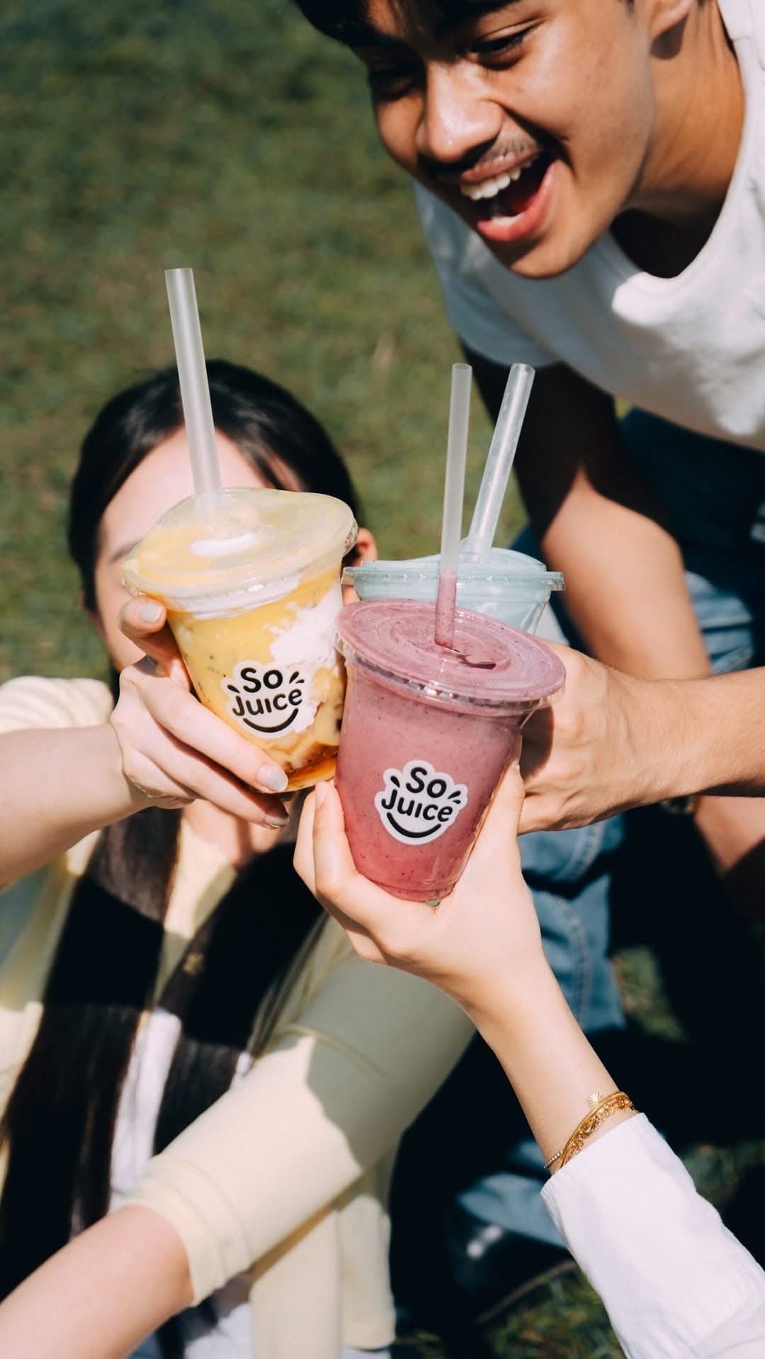 Friends holding SoJuice smoothies